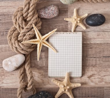 Kağıt, ip, deniz yıldızı, deniz taşları eski ahşap arka plan üzerine
