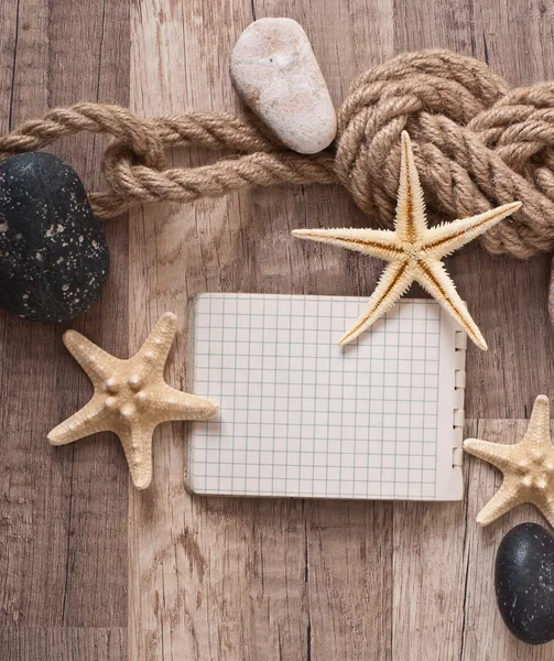 Papíru, lana, hvězdice mořské kameny na staré dřevěné pozadí — Stock fotografie