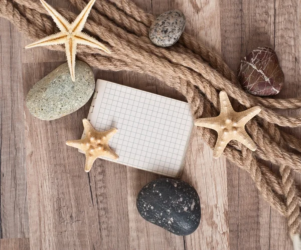 Papier, kabel, starfish, zee stenen op de oude houten achtergrond — Stockfoto