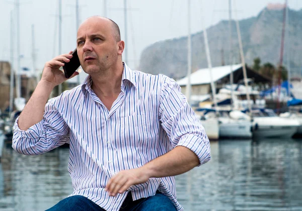 Uomo d'affari che parla al telefono vicino al lussuoso porto — Foto Stock
