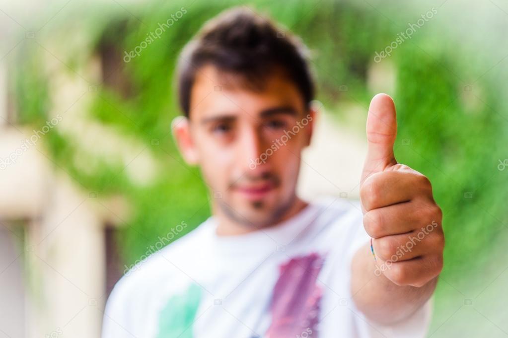 happy young man showing thumb up sign