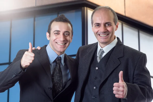 Empresarios dando pulgares hacia arriba signo — Foto de Stock