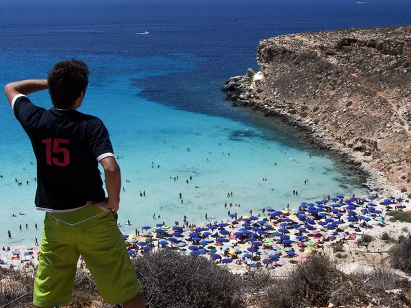 Young tourist looks at the magnificent beach of rabbits in Lampe — Stock Photo, Image