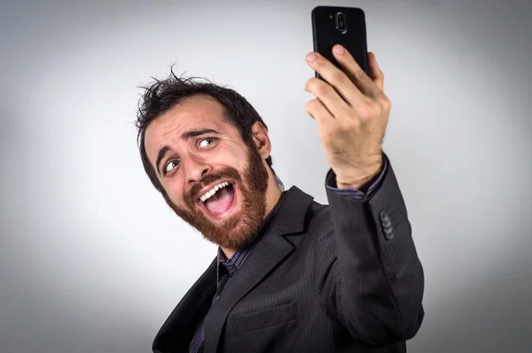 Grappige busnessman is met behulp van zijn smartphone te nemen een selfie — Stockfoto