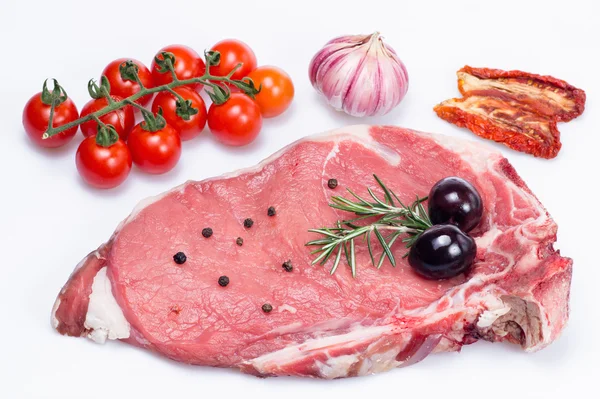 Bistecca alla fiorentina cruda con verdure e spezie isolate — Foto Stock