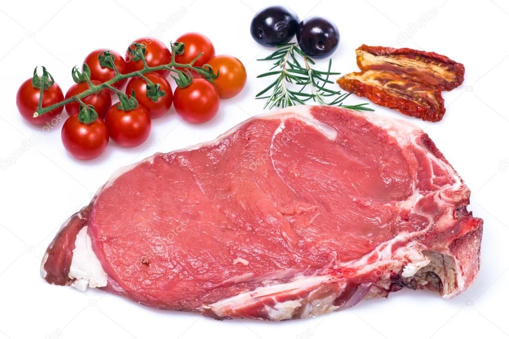 Raw fiorentina steak with vegetables and spice isolated