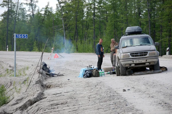 Mannen en auto reparatie op grind weg Kolyma naar Magadan highway bij Y — Stockfoto