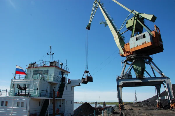 Crane loading coal to ship at Kolyma river port — Stock Photo, Image