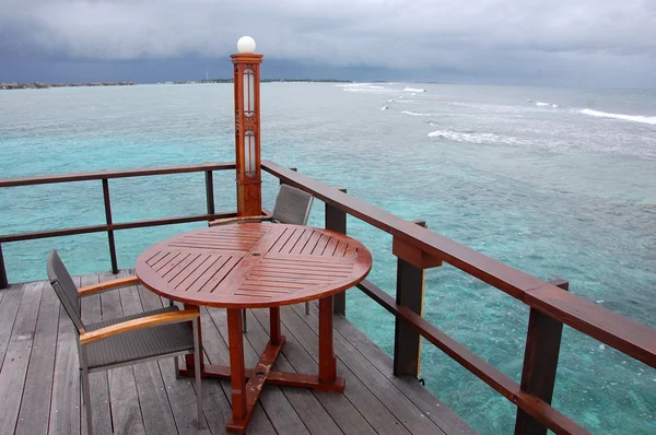 Table and chair at open air cafe with ocean view — Stock Photo, Image