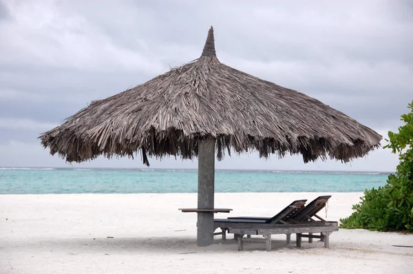 Deck chair and big umbrella at beach — Stock Photo, Image