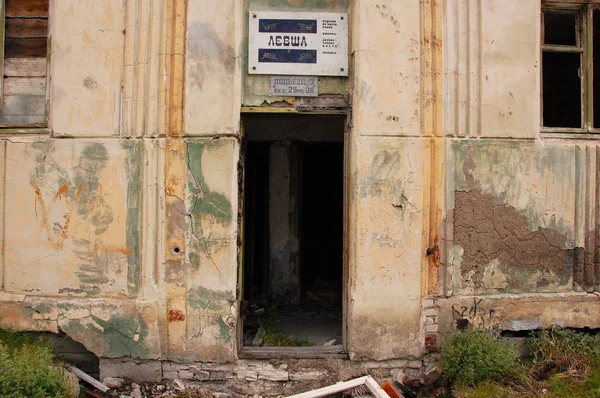 Old information sign above abandoned building entrance — Stock Photo, Image