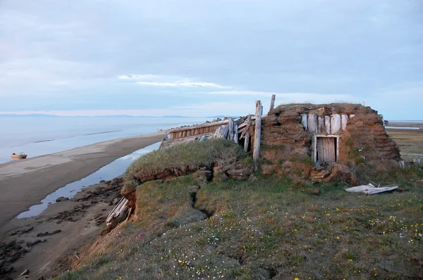 Abandonné cabane de boue brisée à l'île arctique été côte mer calme Images De Stock Libres De Droits