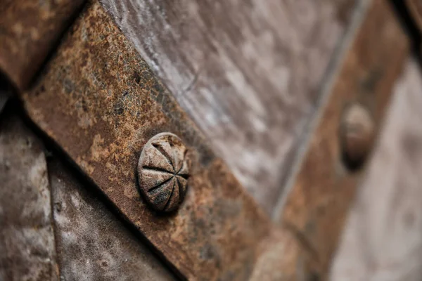 Fragment of the old iron door. Old medieval metal gate background. Elements of architectural decoration of old buildings