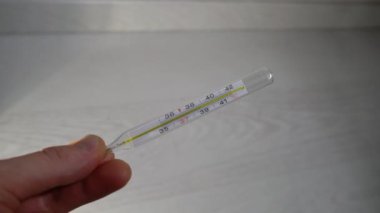 Bir el yüksek sıcaklıkta bir termometreyi tutar.