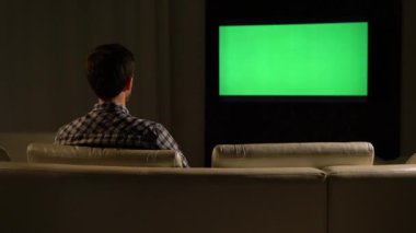 Genç bir adam yeşil ekranı izliyor..