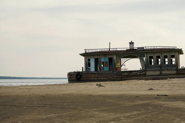 Boş bir plajda terk edilmiş eski bir iniş sahnesi. Sahildeki kırık ahşap bina..