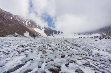 İnsan buzulun yüksek dağlarında yürüyüş yapıyor.