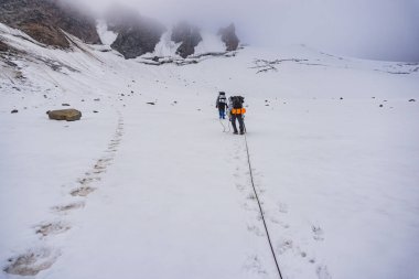 İnsan buzulun yüksek dağlarında yürüyüş yapıyor.