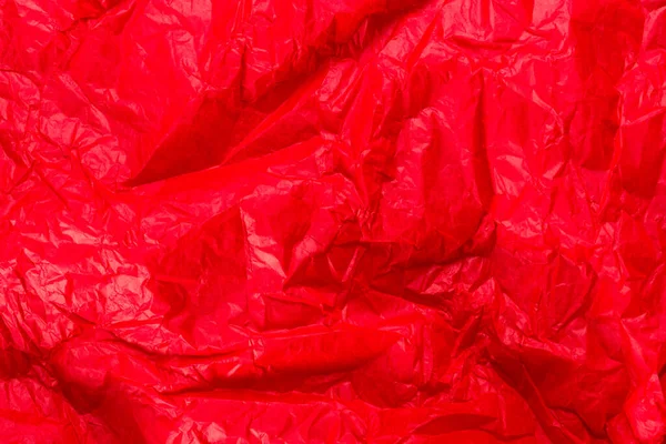 Bright red wrapping paper, crumpled paper texture. Creased sheet background. Textured effect.