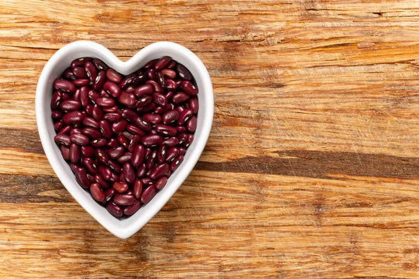 Grano Semi Fagiolo Rosso Una Ciotola Forma Cuore Sfondo Consistenza — Foto Stock