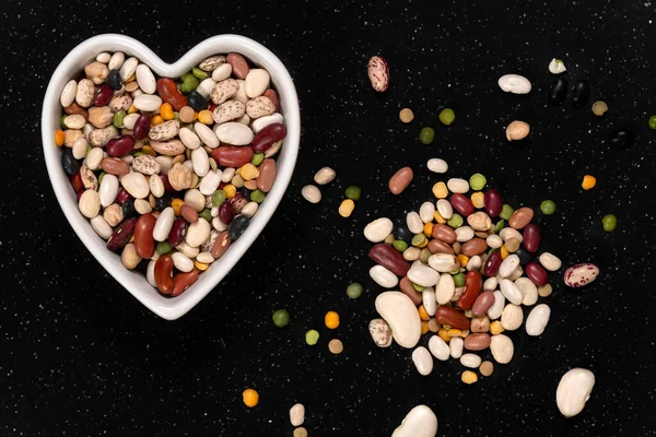 Mixed peas and beans for soup in a heart shaped bowl background and texture. Top view. — Stock Image Mixed Peas Beans Soup Heart Shaped Bowl Background Texture Top Royalty Free Stock Images