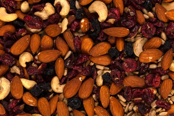 Macro of trail mix with almonds, sunflower seeds, cranberry and raisins , background and texture.