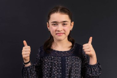 Genç ortaokul öğrencisi başparmak kaldırıyor. Ruh hali ve yüz ifadesi kavramı.