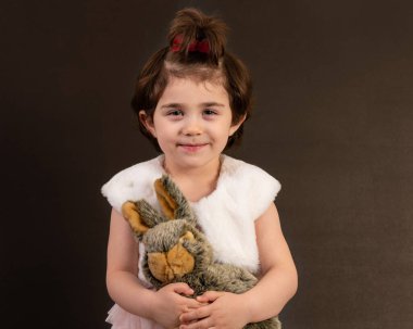 Gülümseyen genç kız pofuduk tavşancığı siyahların üzerinde yalnız tutuyor..