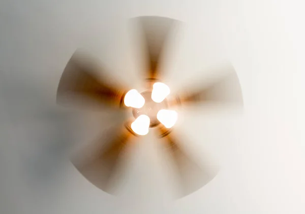 Residential ceiling fan in motion on a white ceiling.
