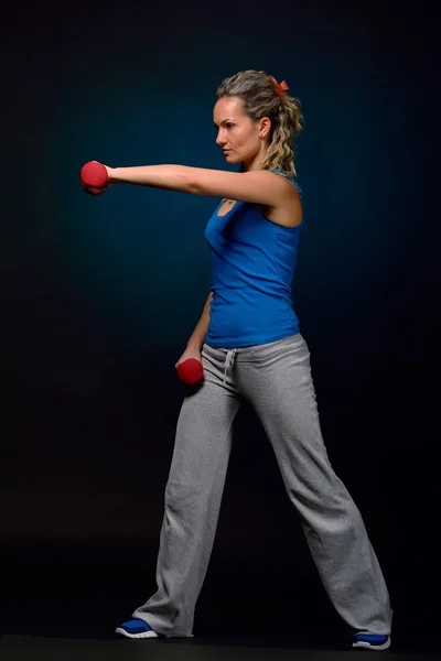 Vacker ung kvinna som tränar i gymmet — Stockfoto