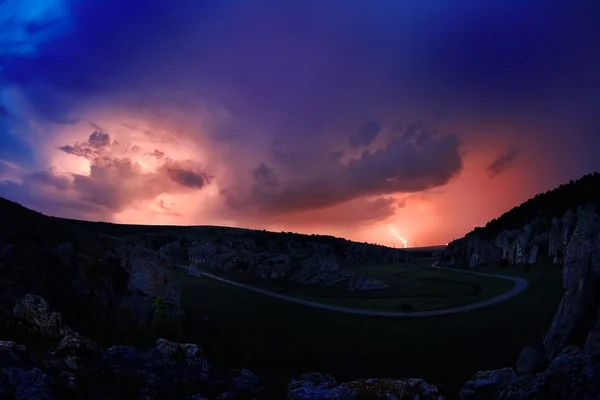 Iluminação e tempestade sobre colinas durante a noite — Fotografia de Stock