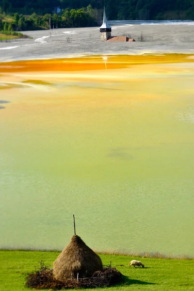 Roter verschmutzter See und überflutete Kirche in Rumänien, Geamana — Stockfoto