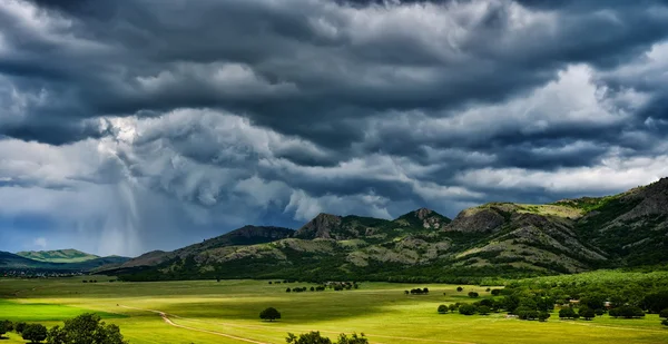 Paesaggio con campi in primavera e cielo nuvoloso — Foto Stock