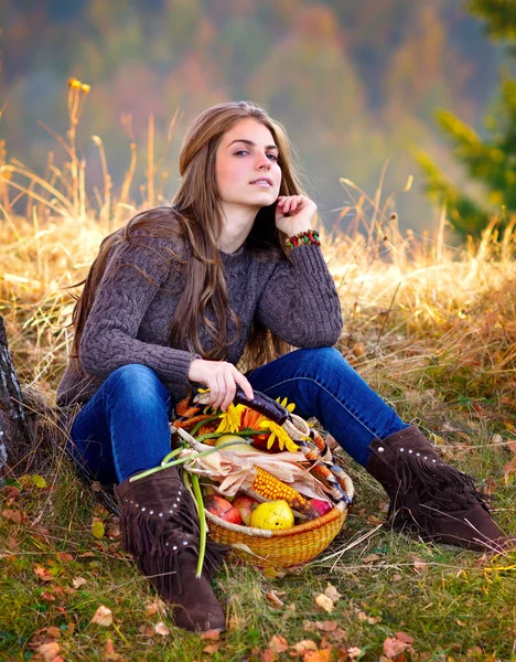 Mujer joven sosteniendo cesta de verduras al aire libre — Foto de Stock