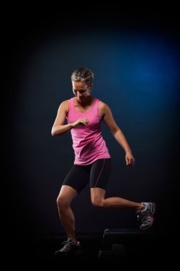 genç kadın spor salonunda adım egzersizleri yapıyor