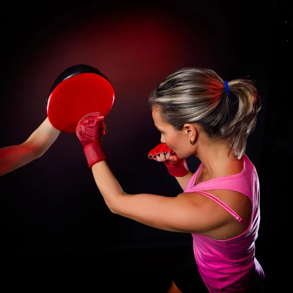 Mujer joven haciendo un duro golpe durante el entrenamiento — Foto de Stock