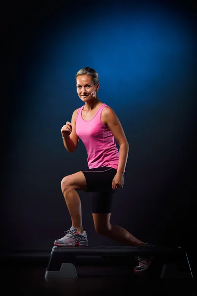 Junge Frau macht Step-Übungen im Fitnessstudio — Stockfoto