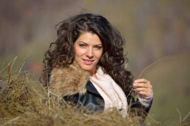 güzel bir genç kadın sonbaharda bir saman yığını altında rahatlatıcı