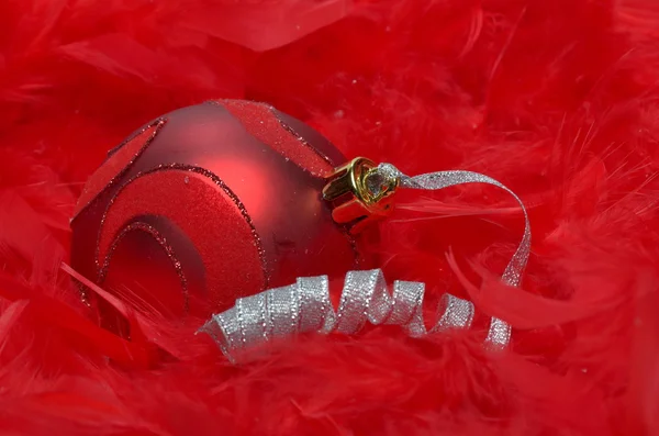 Bola de Navidad sobre plumas rojas — Foto de Stock