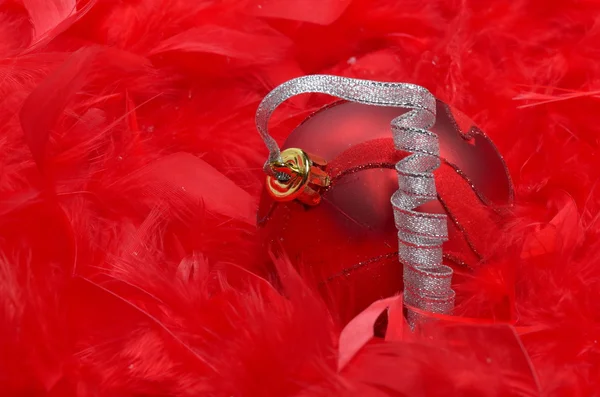 Bola de Navidad sobre plumas rojas — Foto de Stock