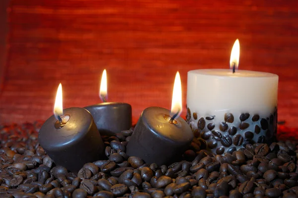 Kaffeebohnen und brennende Kerzen — Stockfoto