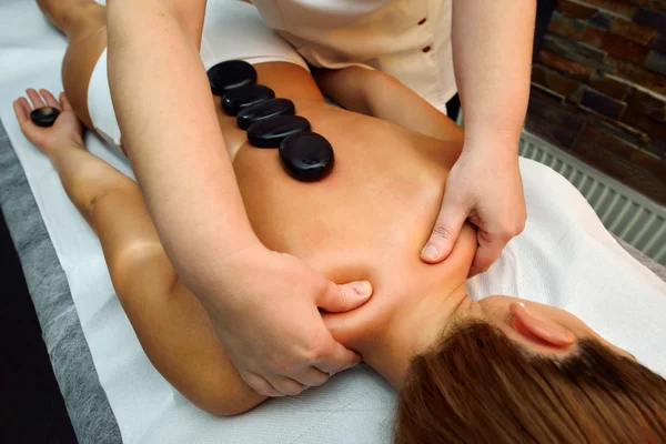 Mooie jonge vrouw liggen terwijl massagetherapeut mas is — Stockfoto