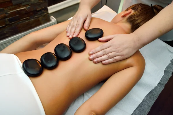 Beautiful young woman lying down while massage therapist is  mas — Stock Photo, Image