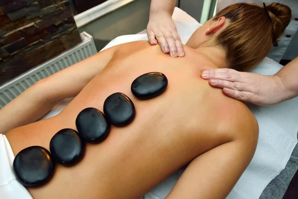 Beautiful young woman lying down while massage therapist is  mas — Stock Photo, Image