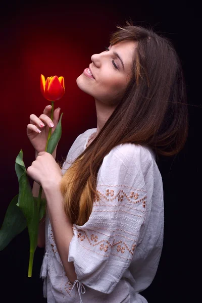 Junge hübsche Frau mit roter Tulpe — Stockfoto