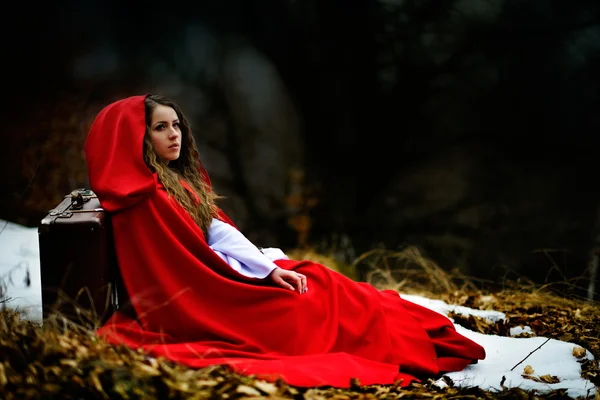 Mulher bonita com manto vermelho e mala — Fotografia de Stock