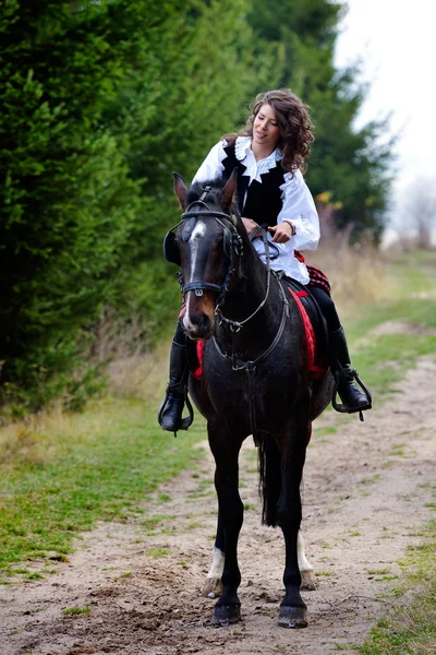 Mladá žena na koni koně venkovní — Stock fotografie