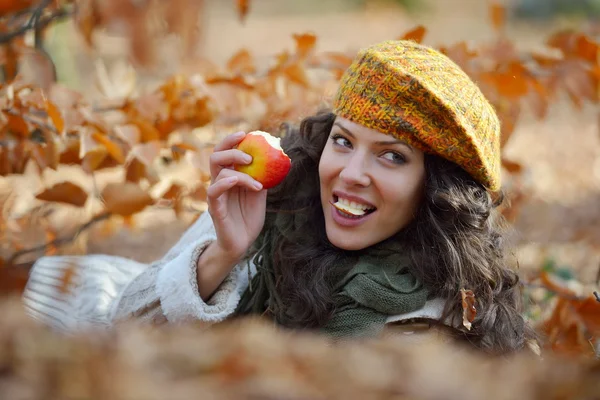 Jonge vrouw eten apple buiten in de herfst — Stockfoto