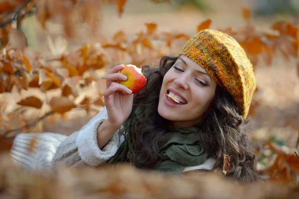 Jonge vrouw eten apple buiten in de herfst — Stockfoto