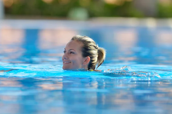 Young woman swimming in the pool on a warm summer day — Stock Photo, Image